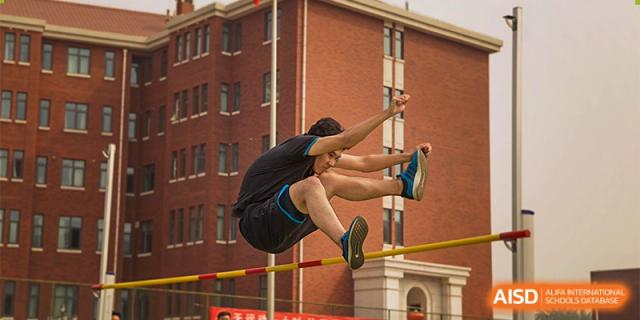 A high-school student from RCF Experimental School in mid-air during a high jump event.