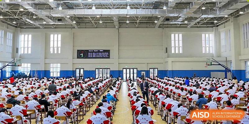 A large number of students from RCF Experimental School seated in an assembly hall for an event or ceremony.