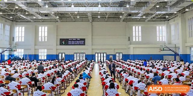A large number of students from RCF Experimental School seated in an assembly hall for an event or ceremony.