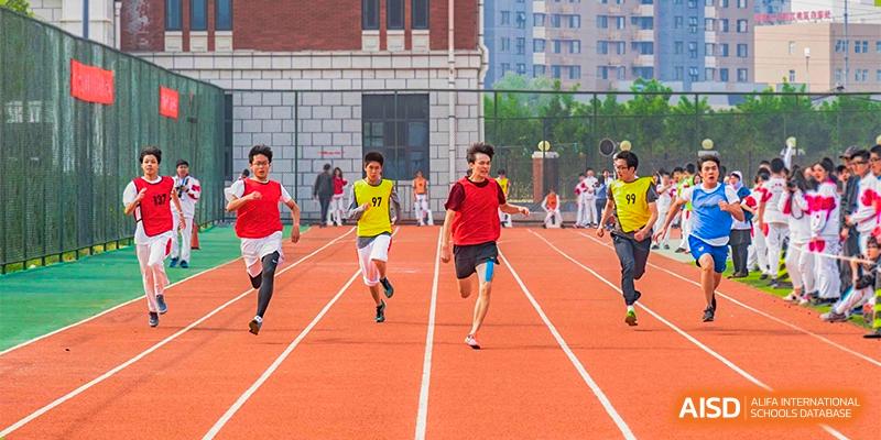 Students from RCF Experimental School running on an outdoor track during a race.