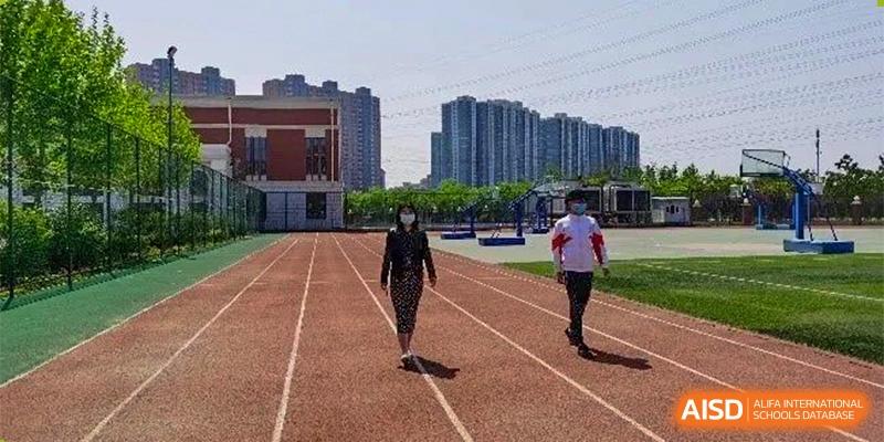 A lone student from RCF Experimental School walking on a running track.