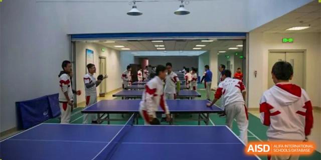 Students from RCF Experimental School playing table tennis in a bright room.