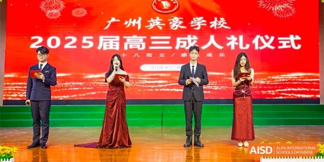 Three students in formal attire stand on a stage with a bright red backdrop during a high school graduation or coming-of-age ceremony at Guangzhou Yinghao School.