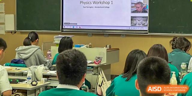 Students in a classroom looking at a presentation displayed on a large screen at Guangdong Experimental High School IFPAD & A-Level.