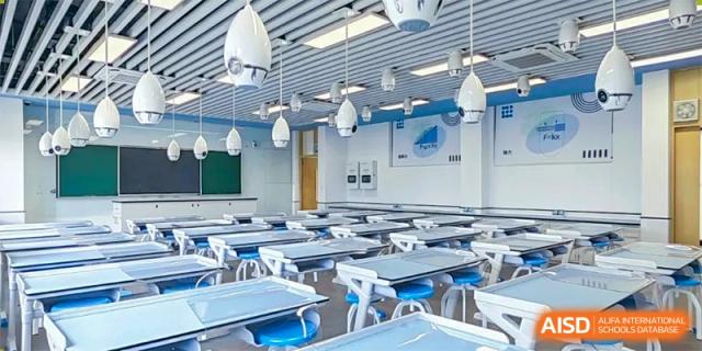 An empty, well-lit modern classroom with individual blue and white desks arranged in rows at Guangdong Experimental High School IFPAD & A-Level.