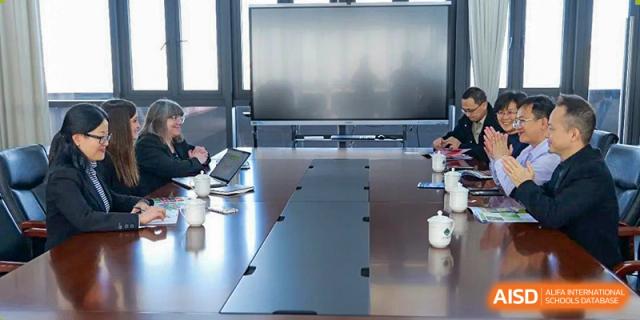A view of a modern conference or meeting room featuring a long dark table and a large display screen at Guangdong Experimental High School IFPAD & A-Level.