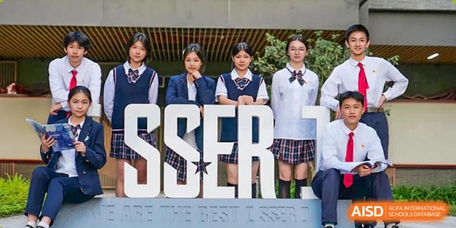 Students in uniform standing behind large "OBSERVER" letters on the campus of Guangdong Experimental High School IFPAD & A-Level.