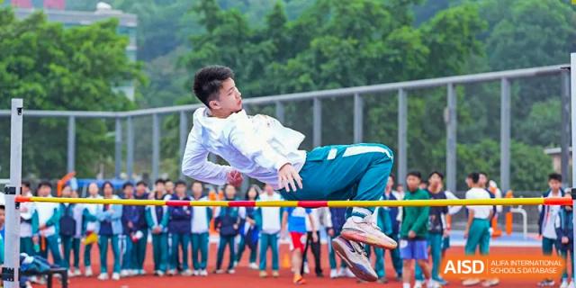A student performing a high jump at a track and field event at Guangdong Experimental High School IFPAD & A-Level.