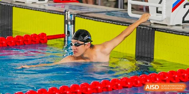 Close-up shot of a student swimmer in the pool, wearing goggles and a swim cap, at Guangdong Experimental High School IFPAD & A-Level.
