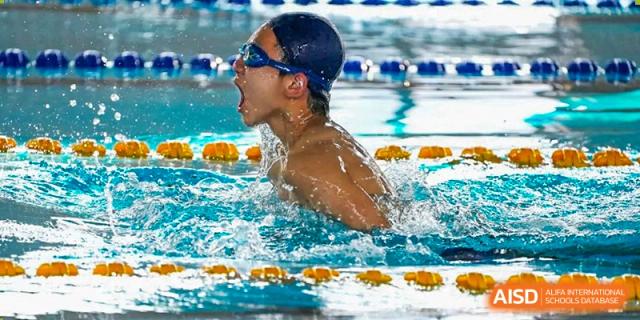 A student taking a breath while swimming freestyle during a competition at Guangdong Experimental High School IFPAD & A-Level.