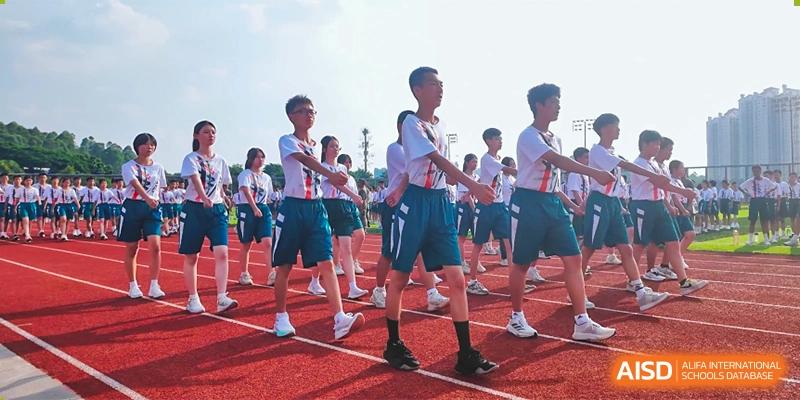 Students in uniform marching or participating in an outdoor activity on a track at Guangdong Experimental High School IFPAD & A-Level.