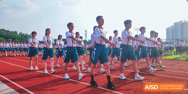 Students in uniform marching or participating in an outdoor activity on a track at Guangdong Experimental High School IFPAD & A-Level.