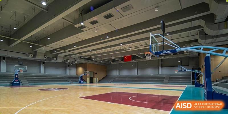 Interior view of a large, well-equipped indoor gymnasium with a basketball court at Guangdong Experimental High School IFPAD & A-Level.