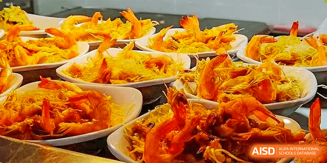 Close-up of several small bowls holding savory dishes like stir-fried shrimp and shredded vegetables at Guangdong Experimental High School IFPAD & A-Level.
