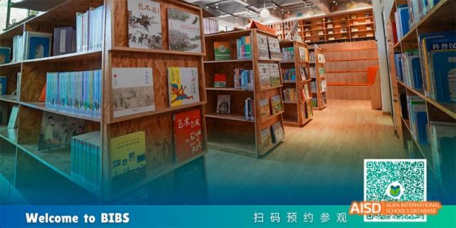 A close-up view of wooden bookshelves filled with books in a library or reading corner, with a bright turquoise floor, at Beanstalk International Bilingual School.