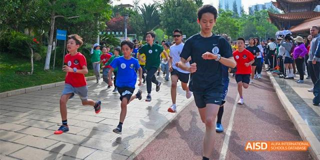 A close-up shot of the legs and feet of multiple people running a race on an outdoor track, at Beanstalk International Bilingual School.
