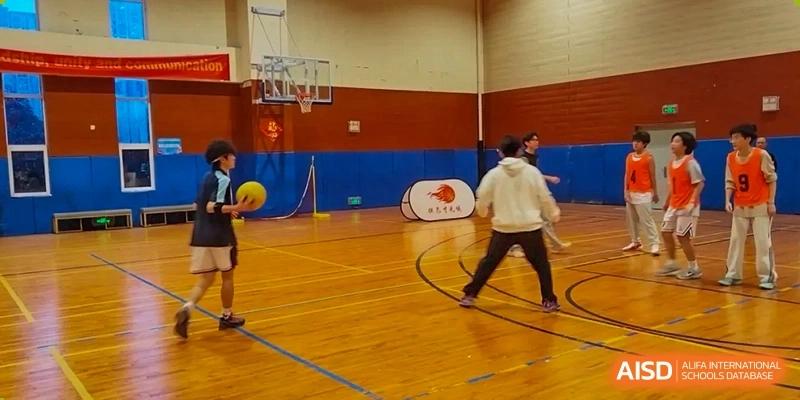 A student prepares to pass a ball during a basketball practice session in the school's indoor athletic facility at Hefei High-tech Sino-Canadian School.