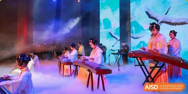 Musicians perform on traditional stringed instruments on a fog-filled stage during a cultural showcase at Hefei High-tech Sino-Canadian School.