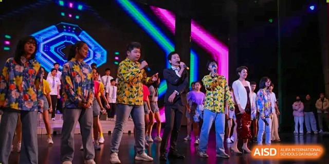 Three boys perform a song on a vibrant stage with colorful neon lights during a school talent show at Hefei High-tech Sino-Canadian School.