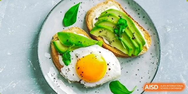 A healthy breakfast plate features avocado toast on whole-grain bread topped with a perfectly fried egg at Hefei High-tech Sino-Canadian School.
