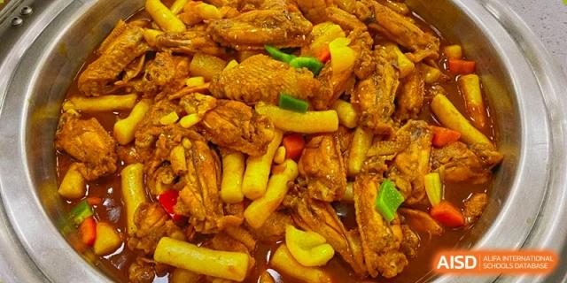 A savory dish of braised chicken wings and rice cakes is served in a rich, golden sauce for a nutritious school meal at Hefei High-tech Sino-Canadian School.