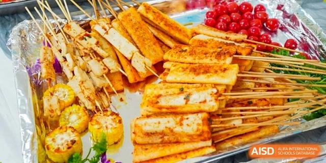 A tray of grilled skewers features seasoned tofu and corn, offering a flavorful vegetarian option for students at Hefei High-tech Sino-Canadian School.