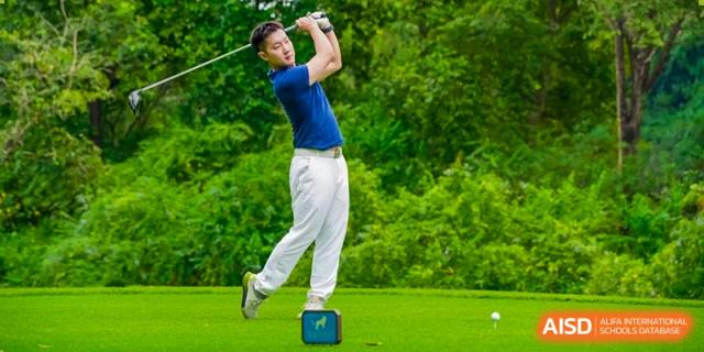 A student from The British School of Guangzhou taking a powerful swing during a golf lesson or tournament.