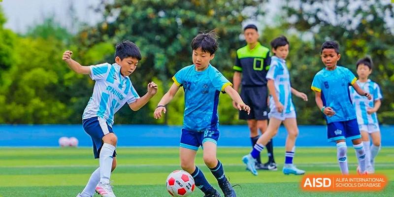 A student from The British School of Guangzhou controlling the ball during a football (soccer) match on the field.