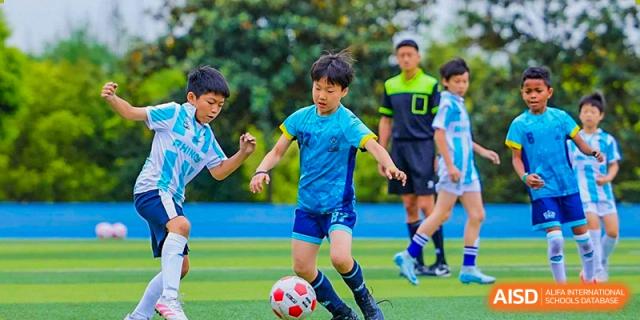 A student from The British School of Guangzhou controlling the ball during a football (soccer) match on the field.