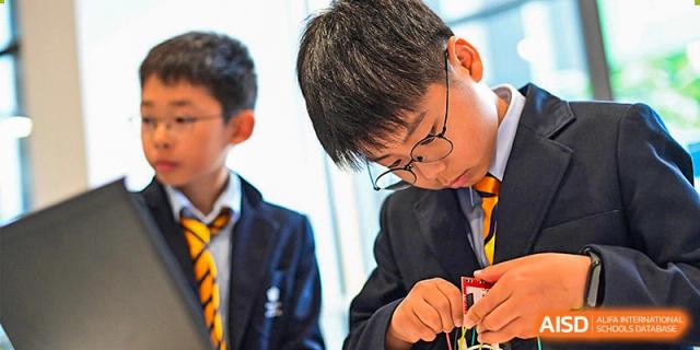 A male student from The British School of Nanjing in glasses, working on a hands-on project with wires.