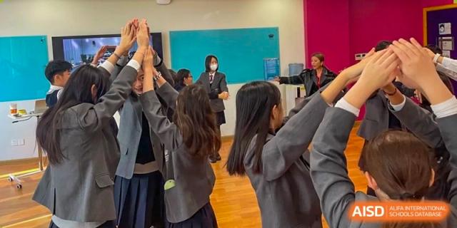 A group of students from The British School of Nanjing with cameras, filming a project or event.