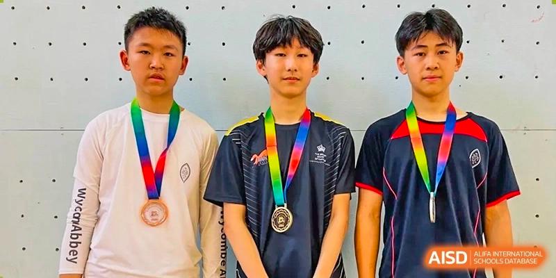 A student from The British School of Nanjing wearing a medal with a rainbow ribbon and a black shirt.