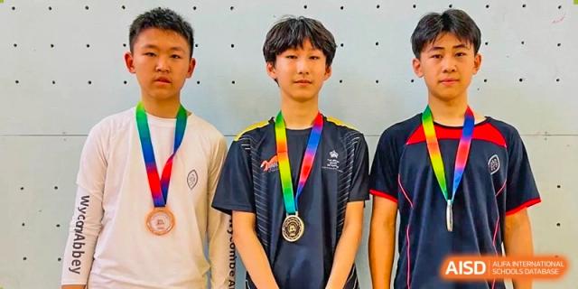 A student from The British School of Nanjing wearing a medal with a rainbow ribbon and a black shirt.