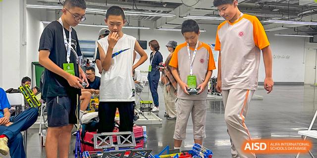 Students from The High School Affiliated To Beijing Normal University participating in a robotics competition or exhibit.