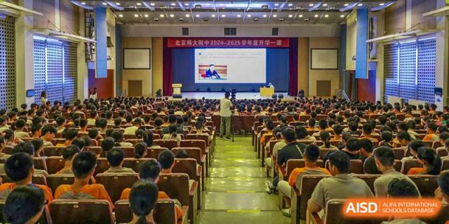 A large audience from The High School Affiliated To Beijing Normal University attending a conference or assembly in a lecture hall.