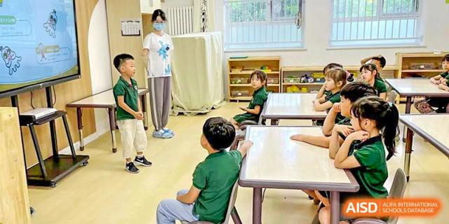 A group of students from The High School Affiliated To Beijing Normal University in a classroom or workshop, participating in a discussion.