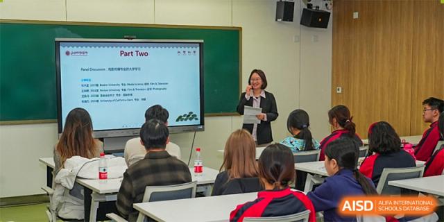 A teacher from The High School Affiliated To Beijing Normal University standing at the front of a classroom, instructing students.