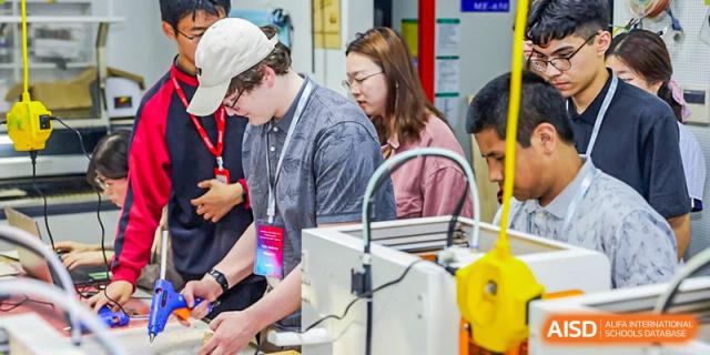 Students from The High School Affiliated To Beijing Normal University working together on a science or engineering project in a lab.