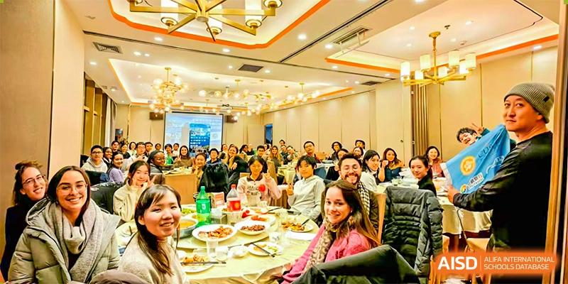 A large group of people from The High School Affiliated To Beijing Normal University attending a banquet or conference in a brightly lit hall.