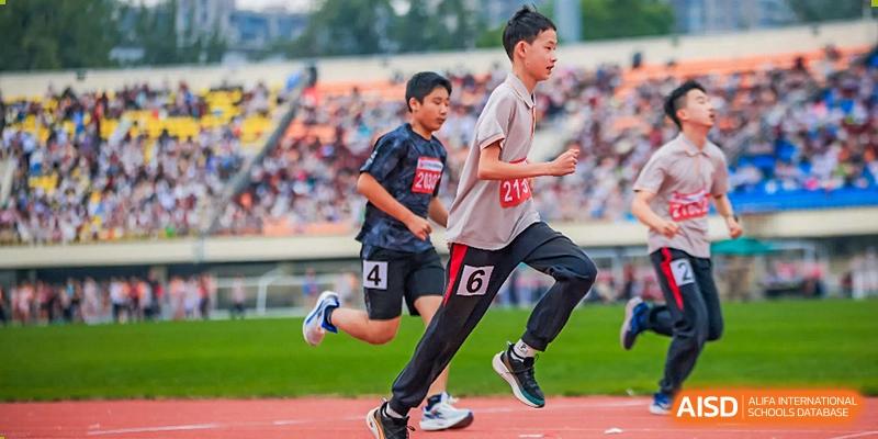 Students from The High School Affiliated To Beijing Normal University participating in a running race on a track.