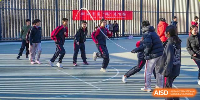 Students from The High School Affiliated To Beijing Normal University participating in a running race on a track.