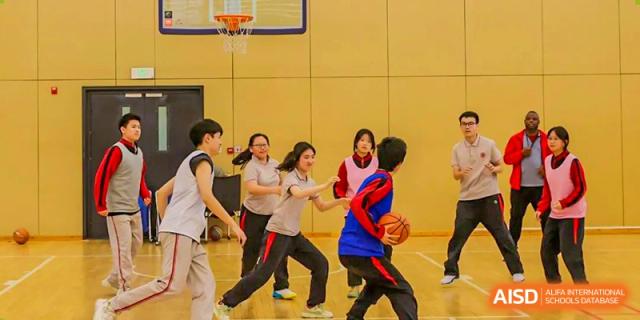 Students from The High School Affiliated To Beijing Normal University playing basketball during a physical education class.