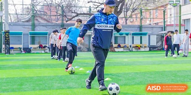 Students from The High School Affiliated To Beijing Normal University playing soccer on an artificial turf field.
