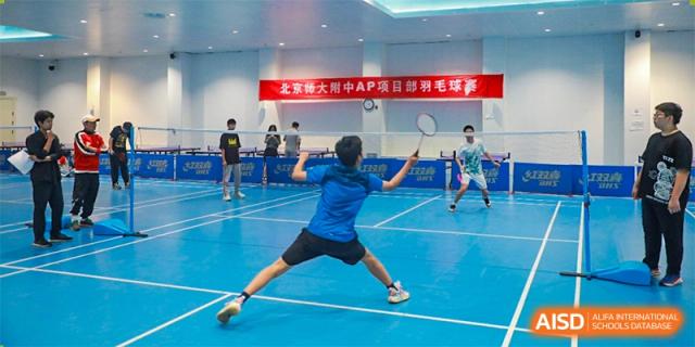 A student from The High School Affiliated To Beijing Normal University playing badminton in an indoor court.