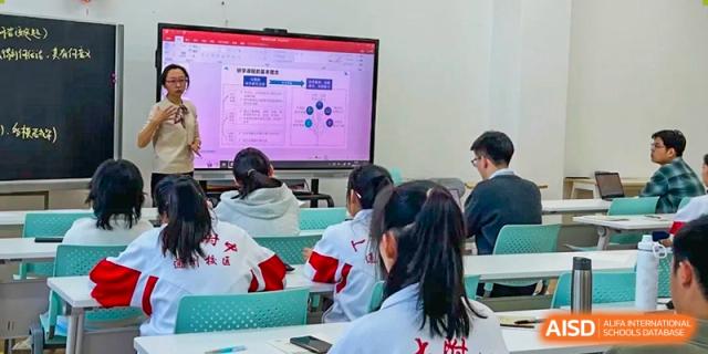 A female student from The High School Affiliated to Renmin University of China, Tongzhou Campus, points at a screen in a classroom.