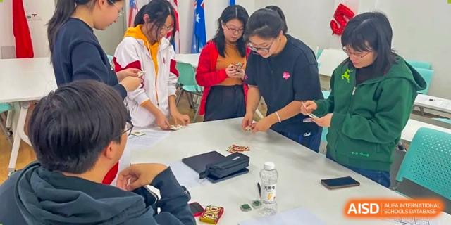 Students from The High School Affiliated to Renmin University of China, Tongzhou Campus, gather and work on a project.