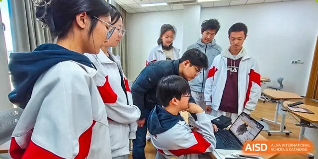 A group of students from The High School Affiliated to Renmin University of China, Tongzhou Campus, works together on a project.