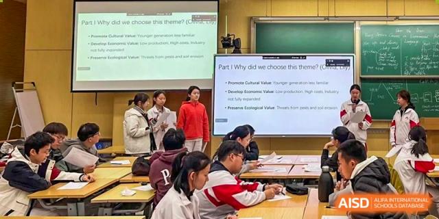 A teacher from The High School Affiliated to Renmin University of China, Tongzhou Campus, points at a screen with a presentation in a classroom.