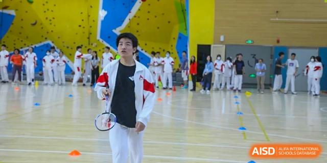 A male student from The High School Affiliated to Renmin University of China, Tongzhou Campus, plays badminton indoors.