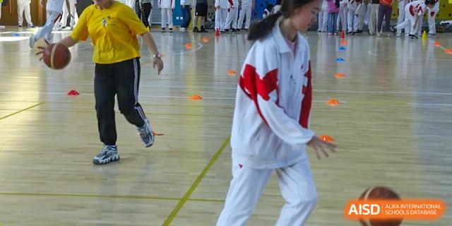Students from The High School Affiliated to Renmin University of China, Tongzhou Campus, participate in a sports drill in a gymnasium.